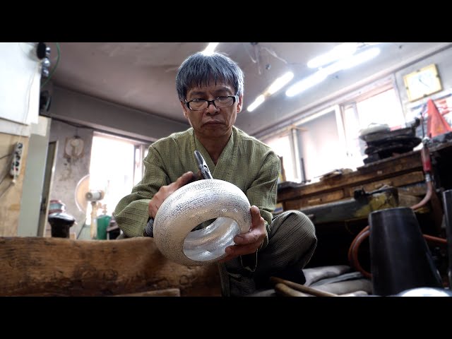 The process of making a silver teapot by hitting it tens of thousands of times. Korean craftsman