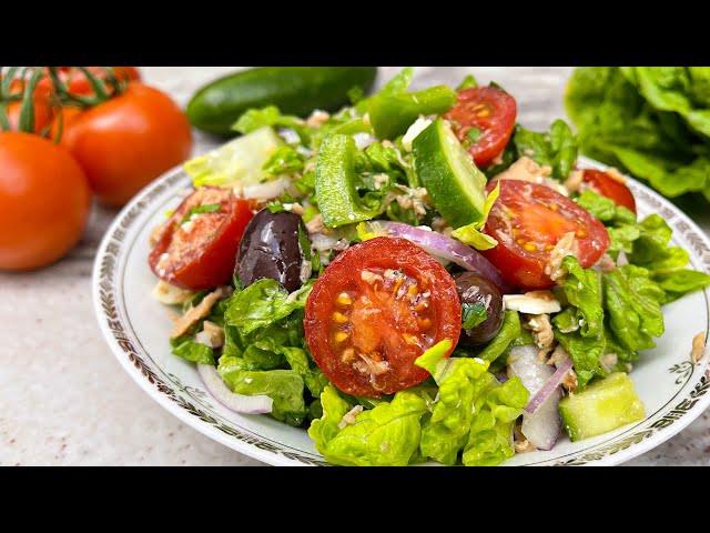 Delicious Greek style salad with feta, olives, tuna and vegetables. Healthy salad.