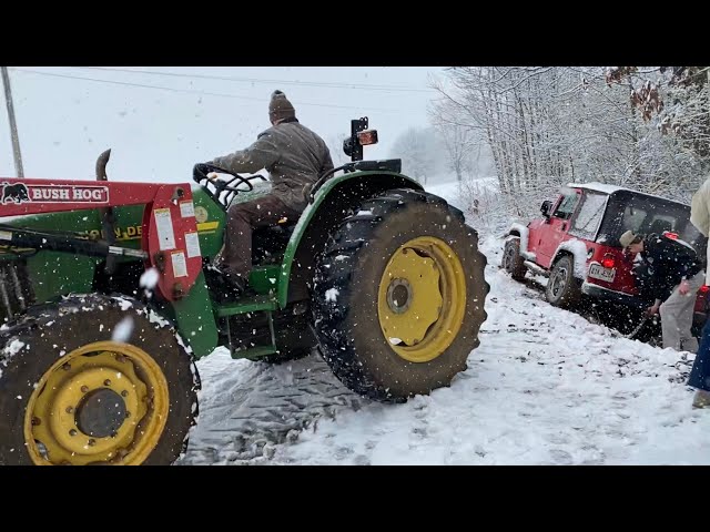 John Deere tractor pulls an F150 and Jeep out of the ditch