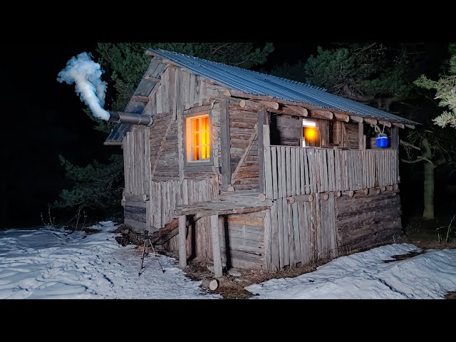 The man repairs the wooden hut he abandoned 10 years ago and hides in it