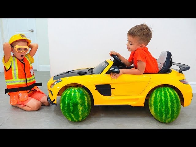 Kinder fahren mit einem Spielzeugauto und wechseln die Reifen. Lustiges Video von Vlad und Nikita