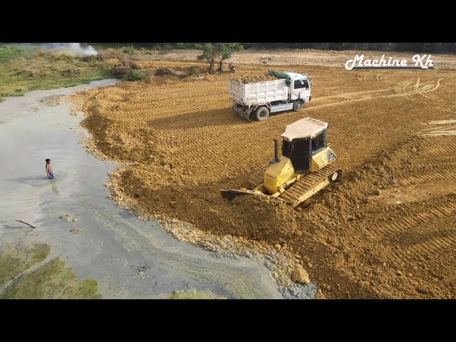 Bulldozer Komatsu D53p process pushing rock and Dumper 25t dumping land to filling up