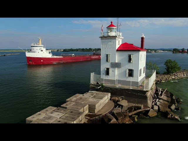 53 year old Great Lakes freighter Frontenac sails from Fairport Harbor by west breakwater lighthouse