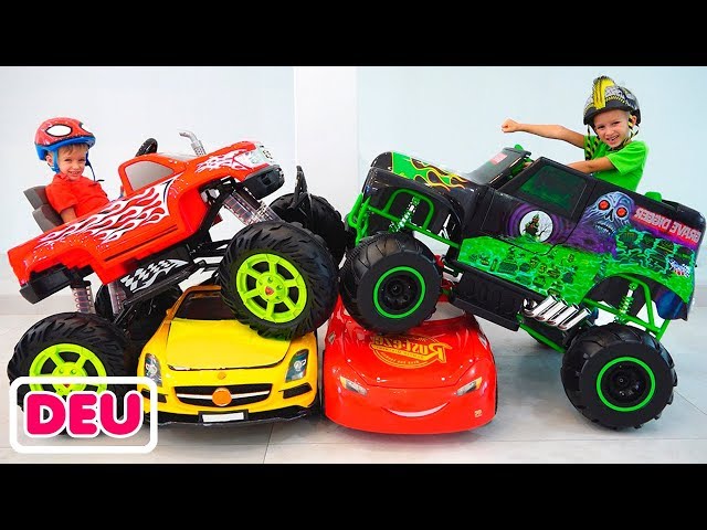 Vlad und Nikita fahren mit einem Spielzeug-Monstertruck und fahren durch die Kinderautos