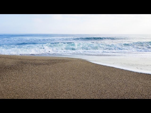 Waves lapping on a sandy beach in the morning