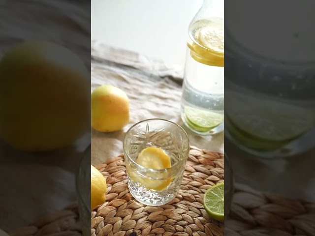 A Person Putting a Slice of Lemon on a Glass of Water