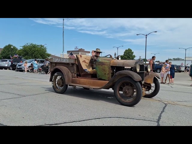 Antique tractors, cars and pickups in a 4th of July parade