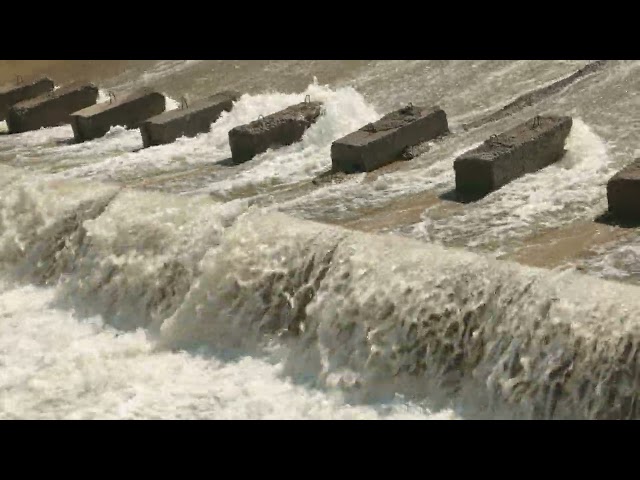 row of chute dentate blocks in concrete water spillway channel slope slowing down the flow of water