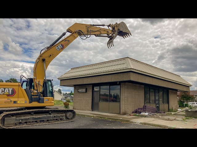 Caterpillar excavator crushes entire retail building