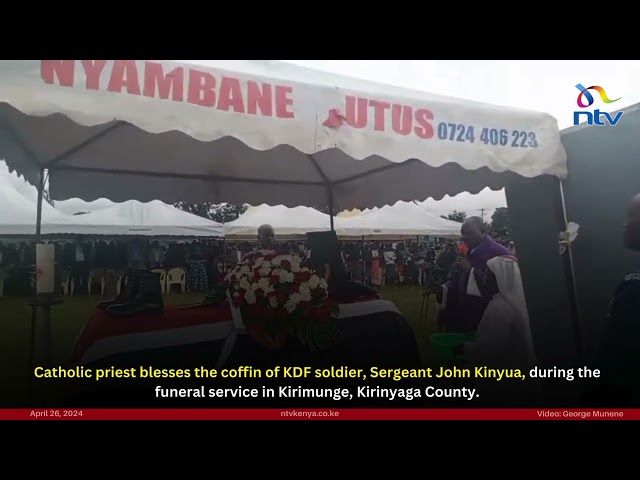 Catholic priest blesses the coffin of KDF soldier, Sergeant John Kinyua, during the funeral service
