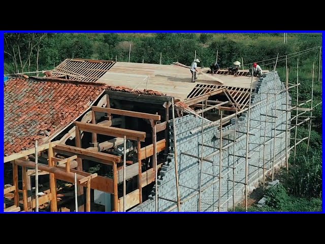 Skilled craftsmen renovate a large wooden house in a Chinese village