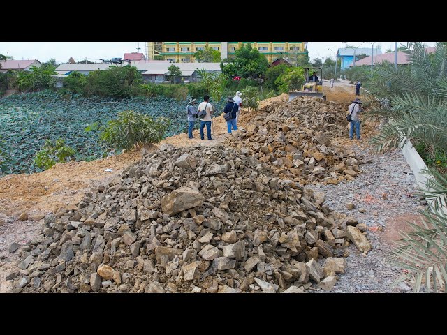 New Action Bulldozer Moving Rock To Build Road Foundation With Mighty Trucks Unloading Rock
