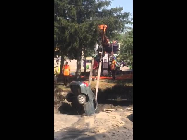 Crews lift car from sinkhole using crane